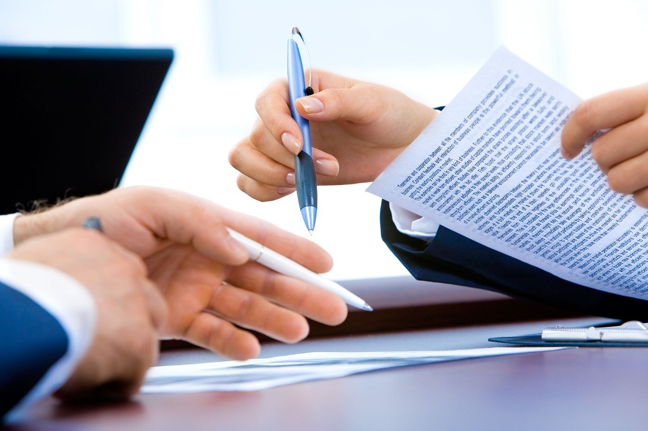 Two Hands of a Man and Woman Holding a Pen 